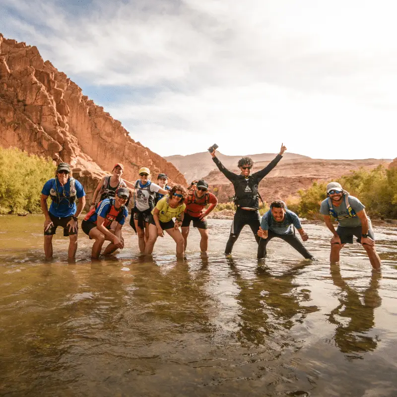 Runners in a river in Morocco while celebrating their running tour vacation