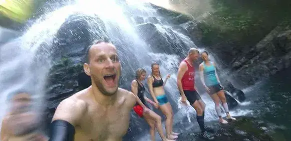 Group of runners jumping to a river