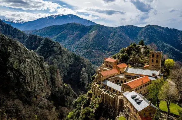 The abbey of Sant Martí del Canigó on a forested cliff below the Pyrenees