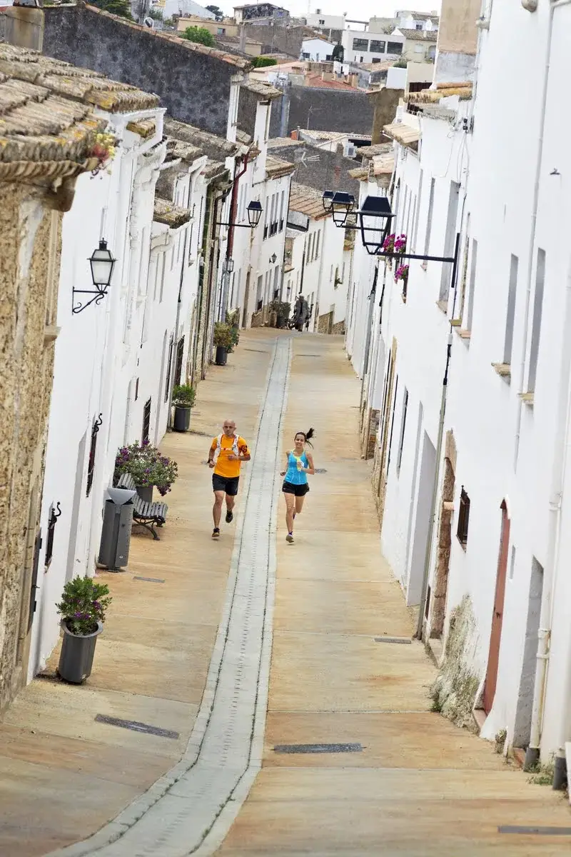 Runners through the white medieval alleys