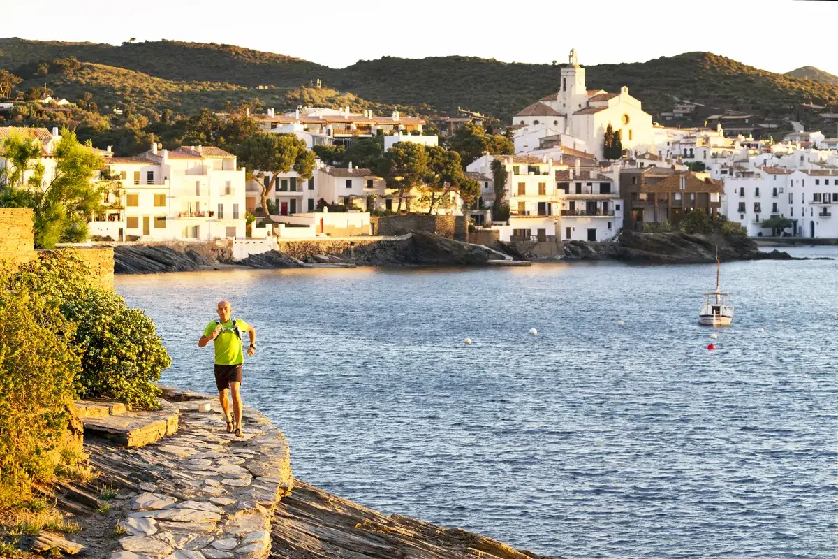 A runner above the whitewashed coastal town of Cadaqués, Costa Brava