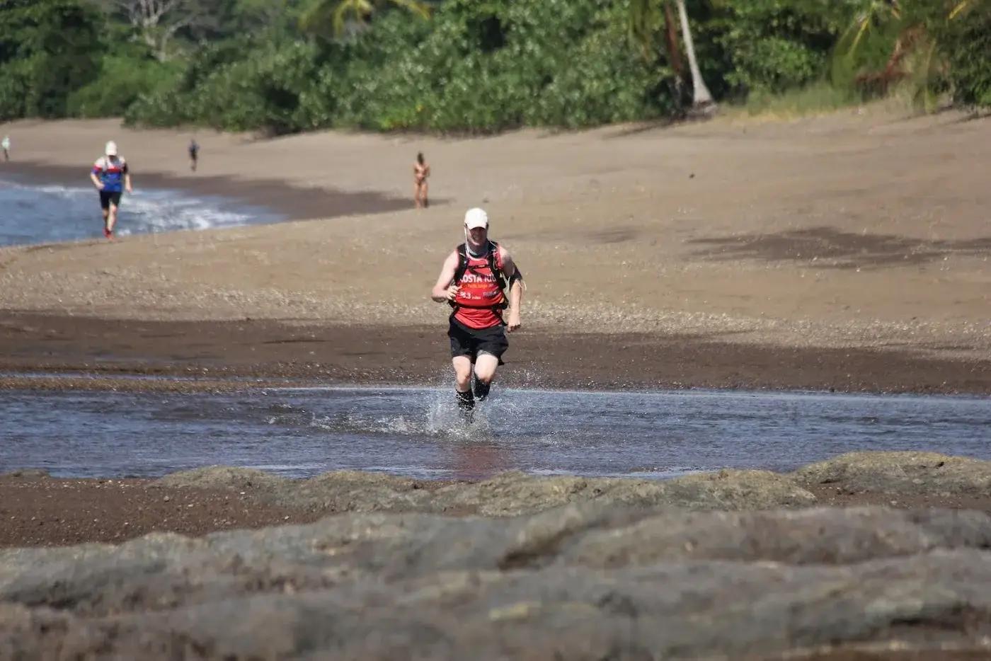 Runner splashing along the Pacific shoreline