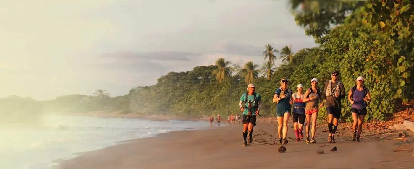 The group running a golden Pacific beach at sunset