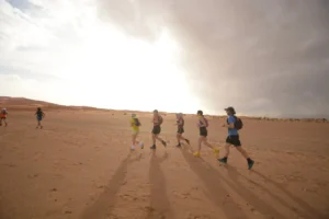 Runners casting long shadows across the desert plain