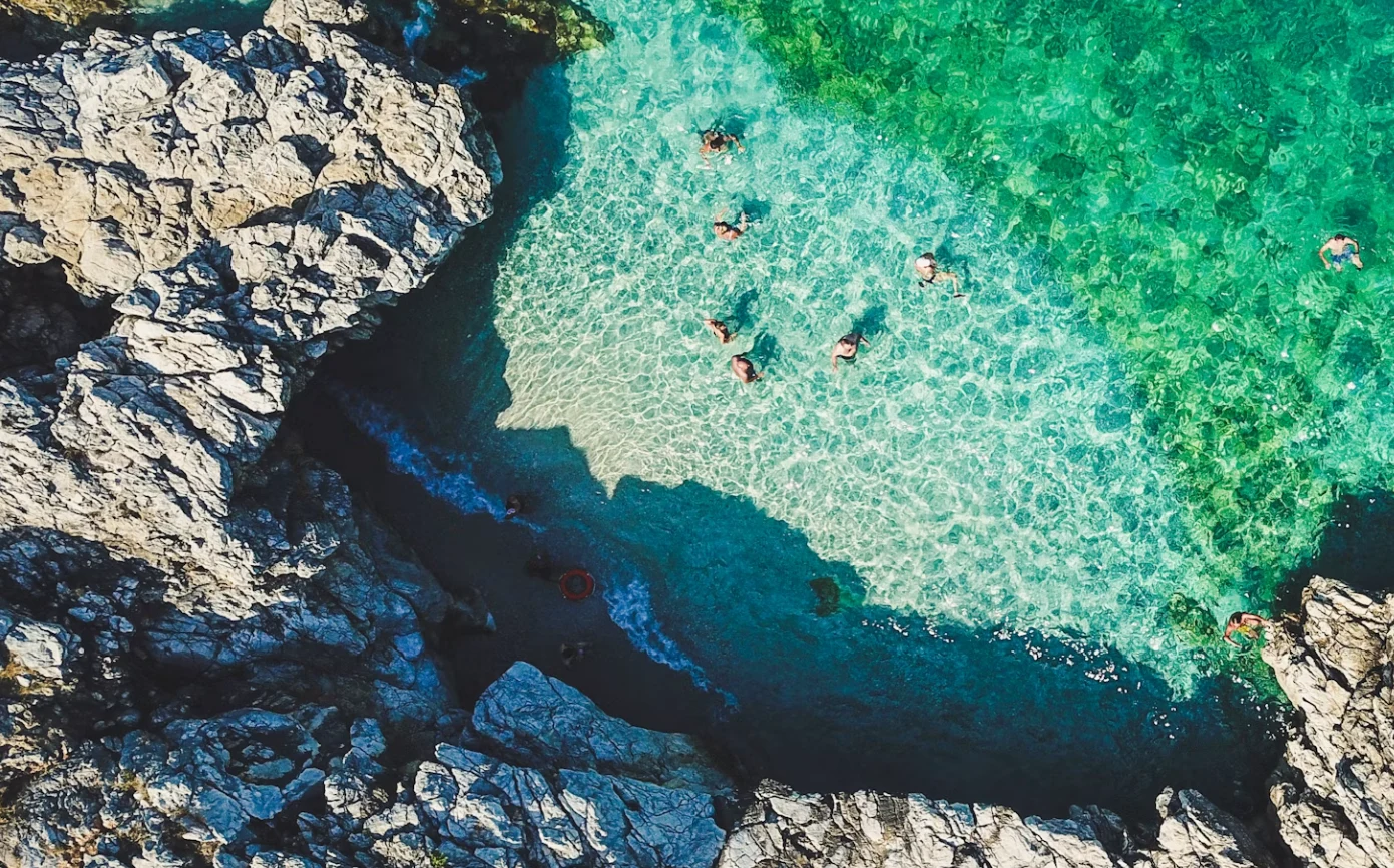 Turquoise cove with swimmers, Sicily