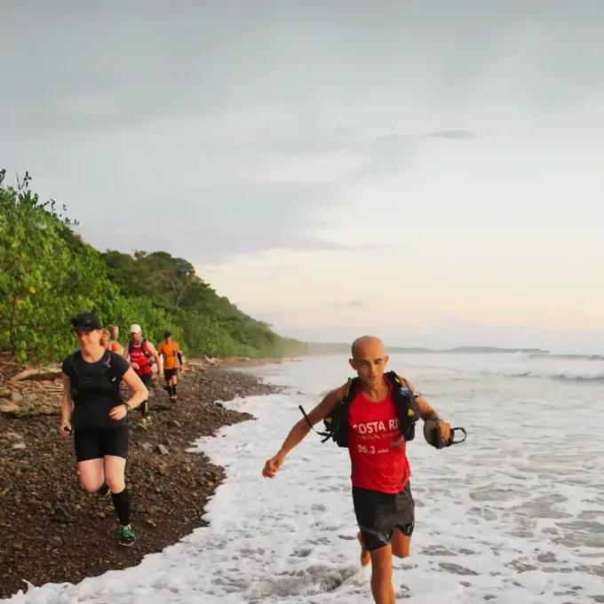 Runners on the Pacific shore at dusk at the end of the Costa Rica crossing