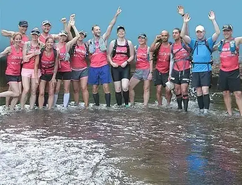 The group standing together in a Costa Rican river with their arms raised