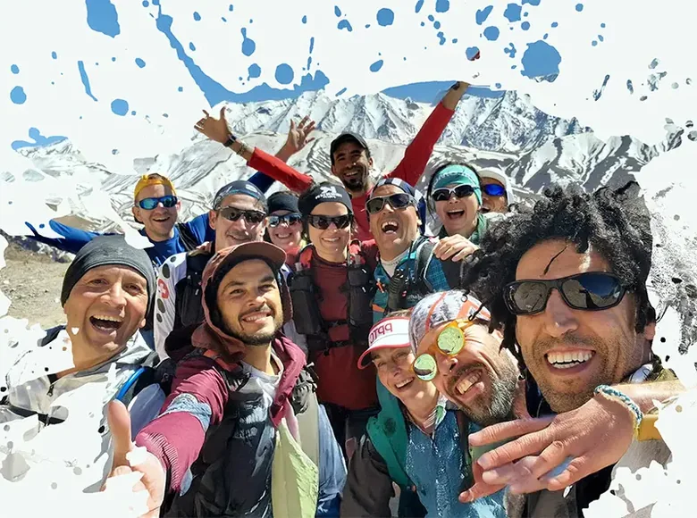 The whole group crowded into one photograph on a snow-covered pass, everyone laughing